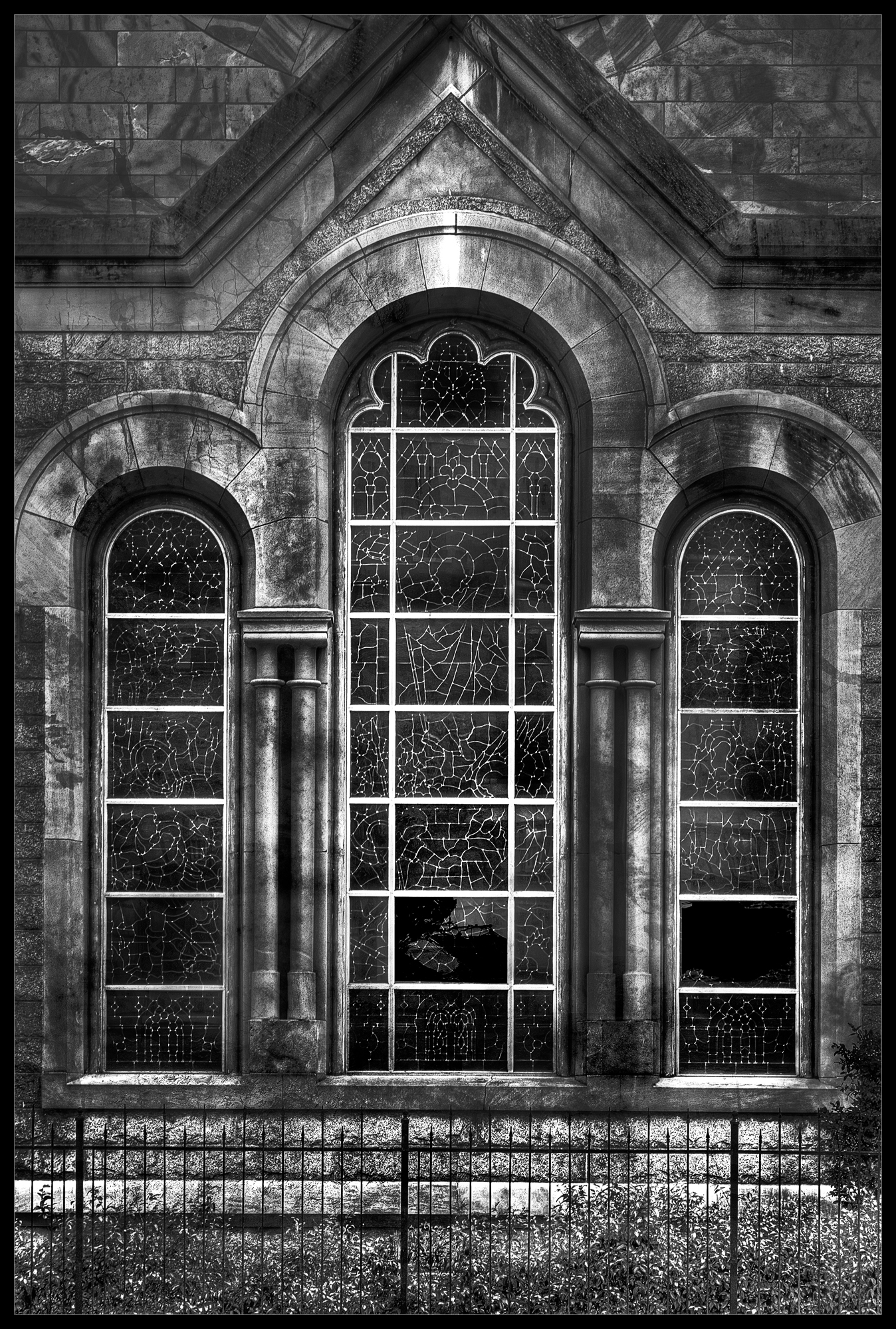 A black-and-white photo of an exterior building with intricate windows.