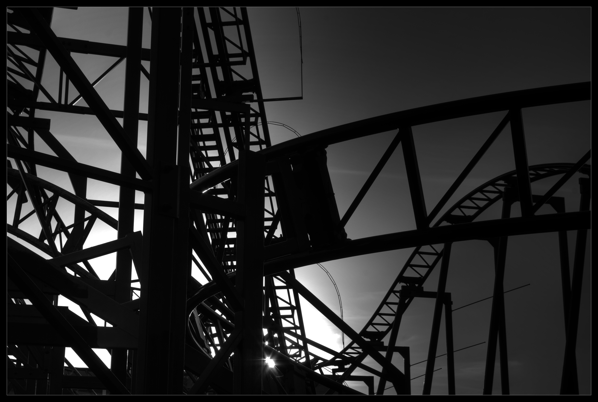Black-and-white photograph of a roller coaster track.