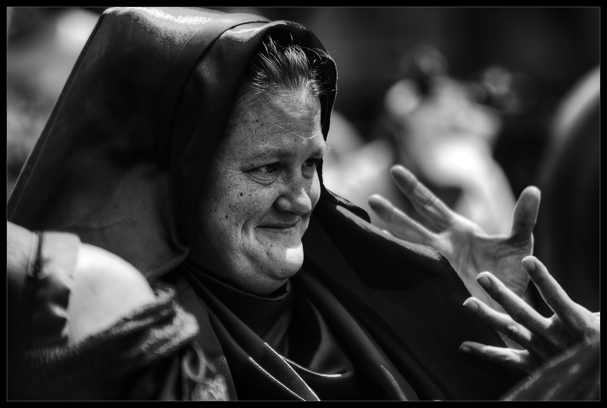 A black-and-white photograph of an older woman listening.