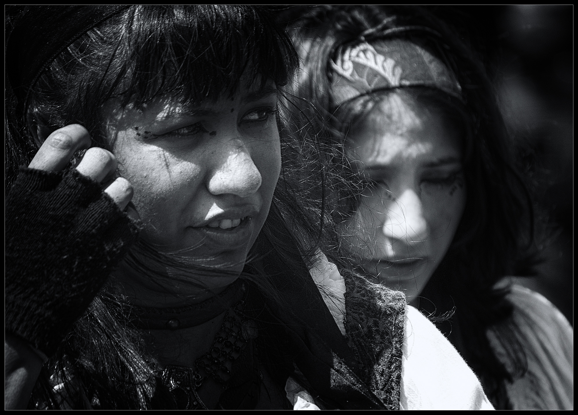 A blue hued black-and-white toned photo of two women.